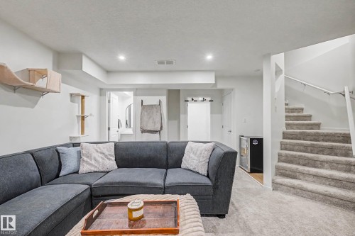 Carpeted living room with a textured ceiling and recessed lighting - 4110 Allan Crescent, Edmonton, AB - Indoor Photo Showing Living Room