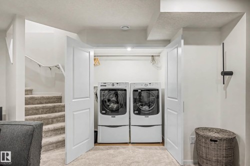 Laundry area featuring separate washer and dryer and a textured ceiling - 4110 Allan Crescent, Edmonton, AB - Indoor Photo Showing Laundry Room