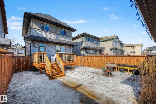 Snow covered back of property featuring a shingled roof, a fenced backyard, a fire pit, and a deck - 4110 Allan Crescent, Edmonton, AB - Outdoor