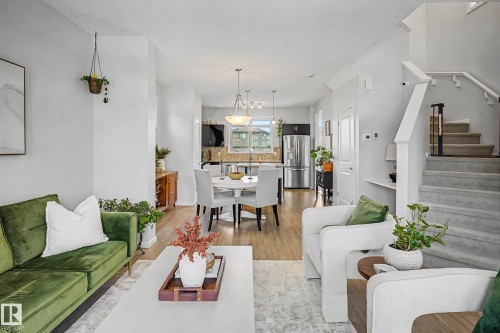 Living area with a textured ceiling and light wood-type flooring - 4110 Allan Crescent, Edmonton, AB - Indoor Photo Showing Living Room