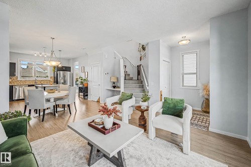 Living room featuring light wood-style flooring and a textured ceiling - 4110 Allan Crescent, Edmonton, AB - Indoor Photo Showing Living Room