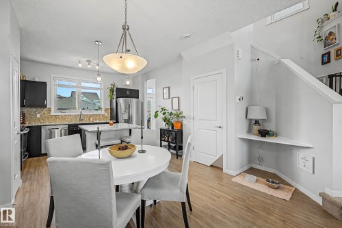 Dining area with a textured ceiling and light wood-type flooring - 4110 Allan Crescent, Edmonton, AB - Indoor Photo Showing Dining Room