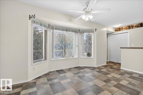 This bright room features a bay window, a ceiling fan, and patterned tile flooring - 4412 Yeoman Close, Onoway, AB - Indoor Photo Showing Other Room