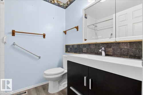 Bathroom featuring a vanity with a white countertop and dark cabinetry, a toilet, and light blue walls - 4412 Yeoman Close, Onoway, AB - Indoor Photo Showing Bathroom