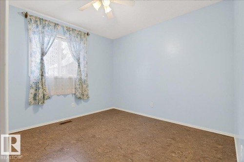 This room features light blue walls, a window with floral curtains, and a ceiling fan with a light fixture - 4412 Yeoman Close, Onoway, AB - Indoor Photo Showing Other Room