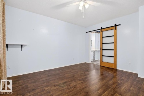 This space features rich wood-look flooring and light blue walls - 4412 Yeoman Close, Onoway, AB - Indoor Photo Showing Other Room