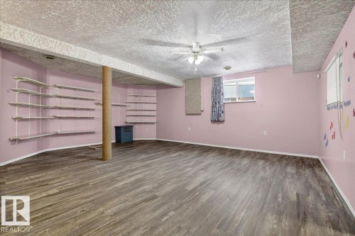 Spacious room featuring wood-look flooring, a ceiling fan, and built-in shelving - 4412 Yeoman Close, Onoway, AB - Indoor Photo Showing Other Room