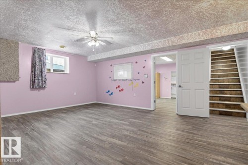 This room features durable plank flooring, a ceiling fan, and a window with a curtain - 4412 Yeoman Close, Onoway, AB - Indoor Photo Showing Other Room