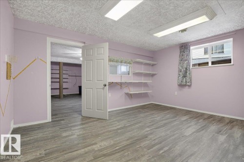 Spacious room featuring light-colored walls, wood-look flooring, and a window with curtains - 4412 Yeoman Close, Onoway, AB - Indoor Photo Showing Other Room