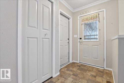 Entryway featuring patterned floor tiles, a white door with a decorative glass insert, and a white bi-fold door - 4412 Yeoman Close, Onoway, AB - Indoor Photo Showing Other Room