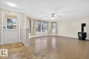 The living area features a bay window, ceiling fan, and a wood-burning stove - 4412 Yeoman Close, Onoway, AB  - Indoor Photo Showing Other Room 