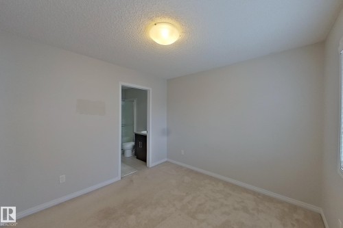 This room features plush carpeting and light-colored walls, providing a neutral canvas - 87 4050 Savaryn Drive, Edmonton, AB - Indoor Photo Showing Other Room