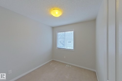 This room features light-colored walls and carpeted flooring - 87 4050 Savaryn Drive, Edmonton, AB - Indoor Photo Showing Other Room