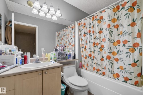 The bathroom features a vanity with a sink, a toilet, and a shower-tub combination - 8109 85 Street, Edmonton, AB - Indoor Photo Showing Bathroom