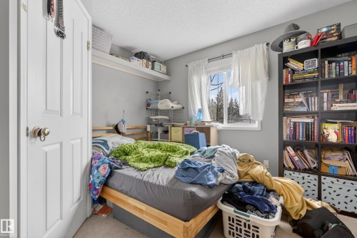 This room features a window providing natural light, a built-in shelf, and a freestanding bookshelf - 8109 85 Street, Edmonton, AB - Indoor