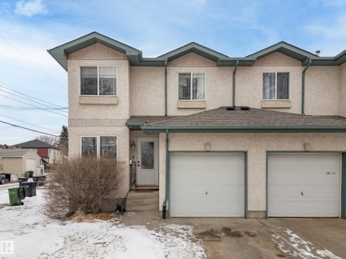 The property features a stucco exterior, a gabled roof, and white garage doors - 8109 85 Street, Edmonton, AB - Outdoor