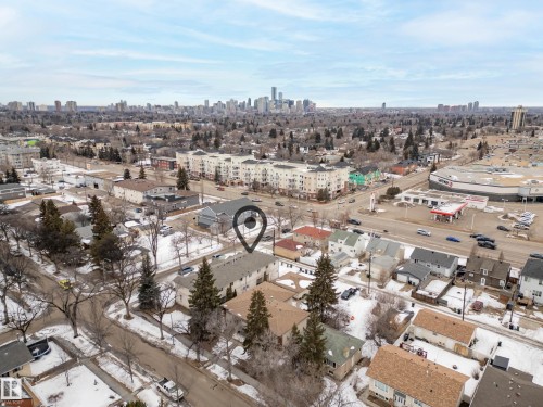 Aerial view showcasing the property within a neighborhood featuring residential homes, mature trees, and a distant cityscape - 8109 85 Street, Edmonton, AB - Outdoor With View