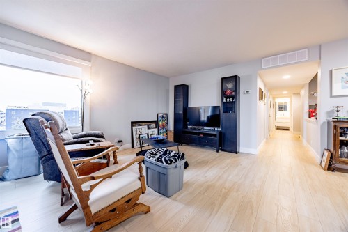 The living area features light-toned flooring, a large window providing natural light, and a spacious layout - 803 12303 Jasper Avenue, Edmonton, AB - Indoor Photo Showing Living Room