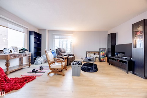 Spacious living area featuring light-toned flooring, expansive windows, and a neutral color palette - 803 12303 Jasper Avenue, Edmonton, AB - Indoor Photo Showing Other Room