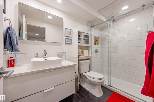 The bathroom features a modern vanity with a vessel sink, a mirrored medicine cabinet, and a tiled shower with a glass enclosure - 803 12303 Jasper Avenue, Edmonton, AB - Indoor Photo Showing Bathroom