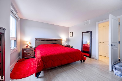 Room featuring light-colored flooring, a window with roller blinds, and a white door with a silver handle - 803 12303 Jasper Avenue, Edmonton, AB - Indoor Photo Showing Bedroom