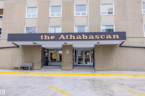 The property features a prominent building entrance with a clear sign, a concrete facade, and multiple windows - 803 12303 Jasper Avenue, Edmonton, AB - Outdoor