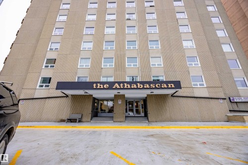 The property exterior features a prominent building entrance with a clear sign and a functional bench - 803 12303 Jasper Avenue, Edmonton, AB - Outdoor With Facade