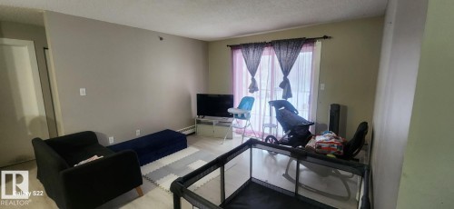 Living area with light-colored flooring and neutral-toned walls - 204 11218 80 Street, Edmonton, AB - Indoor