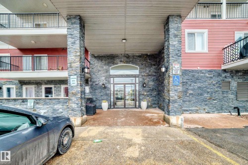 The property features an entrance with a stone facade and a covered walkway - 102 111 Edwards Drive, Edmonton, AB - Outdoor With Exterior
