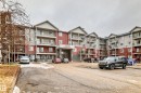 The property features a multi-story residential building with private balconies and an integrated covered entrance - 102 111 Edwards Drive, Edmonton, AB  - Outdoor With Facade 