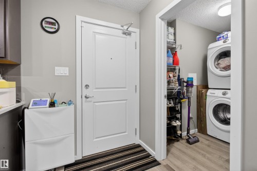 The entryway features a white door and light gray walls, with a striped floor mat - 134 148 Ebbers Boulevard, Edmonton, AB - Indoor Photo Showing Laundry Room