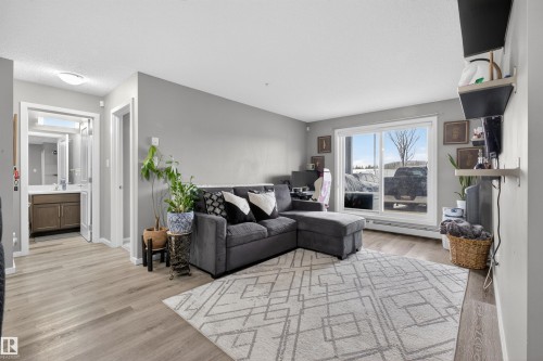 Living area featuring light wood-style flooring and light gray walls - 134 148 Ebbers Boulevard, Edmonton, AB - Indoor Photo Showing Living Room