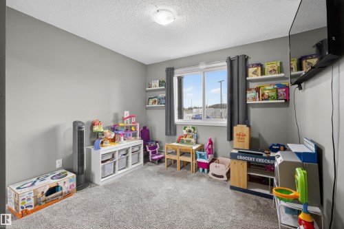 This room features light grey walls, a window with dark grey curtains, and a light-colored carpet - 134 148 Ebbers Boulevard, Edmonton, AB - Indoor