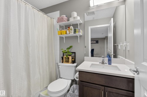 Bathroom with a shower, toilet, and vanity featuring a white countertop and a mirror above - 134 148 Ebbers Boulevard, Edmonton, AB - Indoor Photo Showing Bathroom
