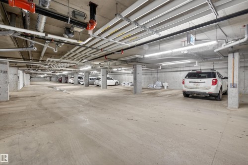 Underground parking with concrete floors, exposed concrete pillars, and overhead lighting - 134 148 Ebbers Boulevard, Edmonton, AB - Indoor Photo Showing Garage