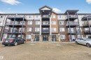 The property features a multi-story exterior with a combination of light and dark siding, stone accents, and several balconies - 134 148 Ebbers Boulevard, Edmonton, AB  - Outdoor With Facade 