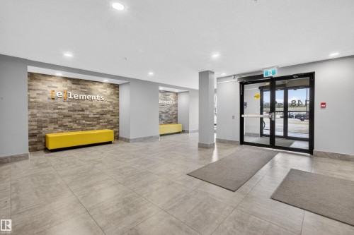 The building entrance features glass doors, recessed lighting, and a grey tiled floor - 134 148 Ebbers Boulevard, Edmonton, AB - Indoor Photo Showing Other Room