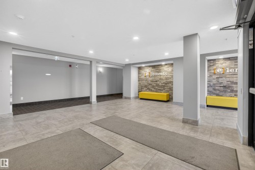The property features a bright and spacious entryway with light-colored tile flooring, recessed lighting, and wall sconces - 134 148 Ebbers Boulevard, Edmonton, AB - Indoor Photo Showing Other Room