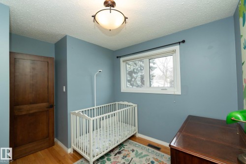 This room features hardwood flooring, light blue walls, and a window providing natural light - 54 Beaverbrook Crescent, St. Albert, AB - Indoor Photo Showing Bedroom