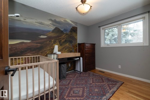 This room features hardwood floors, a large window, and a ceiling light fixture - 54 Beaverbrook Crescent, St. Albert, AB - Indoor