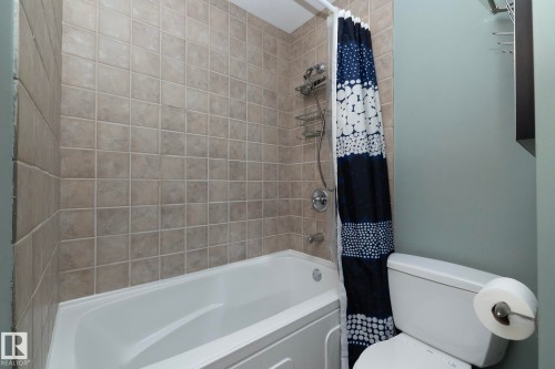 Bathroom featuring a white bathtub, light-colored tiled walls, and a toilet - 54 Beaverbrook Crescent, St. Albert, AB - Indoor Photo Showing Bathroom