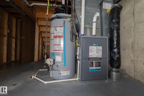 The property includes a water heater and furnace, providing essential utilities - 54 Beaverbrook Crescent, St. Albert, AB - Indoor Photo Showing Basement