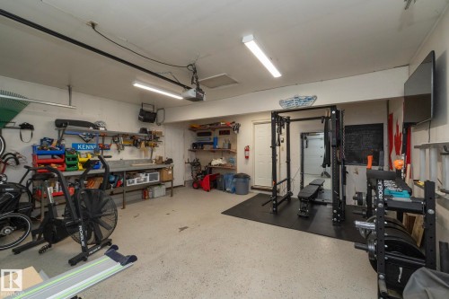 The property features a versatile garage space with a workshop area and a dedicated fitness zone - 54 Beaverbrook Crescent, St. Albert, AB - Indoor Photo Showing Garage