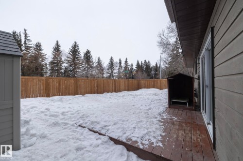 The property features a spacious yard with a wooden privacy fence, a storage shed, and a wooden deck - 54 Beaverbrook Crescent, St. Albert, AB - Outdoor