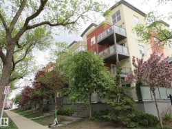 Contemporary multi-story building featuring stucco facade, individual balconies with glass railings, and multiple windows - 
