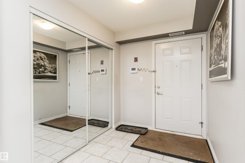 The property entrance features a white door, light-colored walls, and tiled flooring - 107 10118 106 Avenue, Edmonton, AB - Indoor Photo Showing Other Room