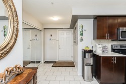 The property features a kitchen with dark wood cabinetry, a tiled backsplash, and stainless steel appliances - 