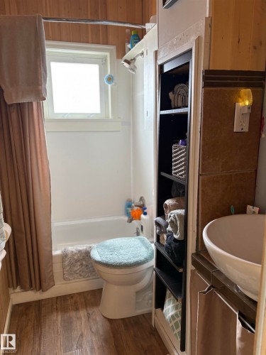 The bathroom features, a window, a bathtub with a shower head, and a vanity with an integrated vessel sink. - 5117 52 Avenue, Elk Point, AB - Indoor Photo Showing Bathroom