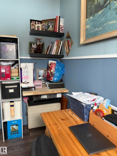 This space features light blue walls with a white chair rail, complemented by two wall-mounted shelves. This is the second bedroom which can also be used as a craft room or an office. - 5117 52 Avenue, Elk Point, AB - Indoor Photo Showing Other Room