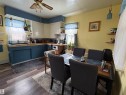 Kitchen and dining area featuring wood-look flooring, light yellow walls, and a ceiling fan with integrated lighting. - 5117 52 Avenue, Elk Point, AB  - Indoor Photo Showing Other Room 
